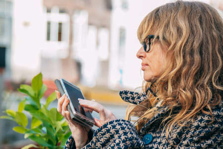 woman typing on mobile phone in the streetの写真素材