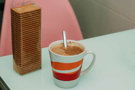 cup of milk with cocoa and package of cookiesの写真素材