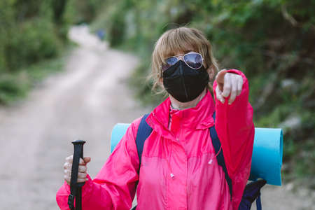 woman with mask and backpack hiking or pilgrimageの写真素材
