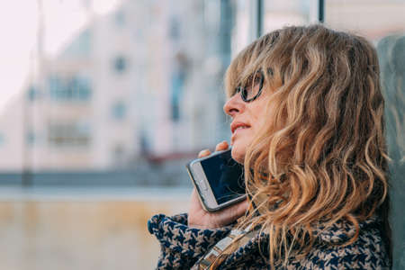 woman talking on mobile phone in the streetの写真素材