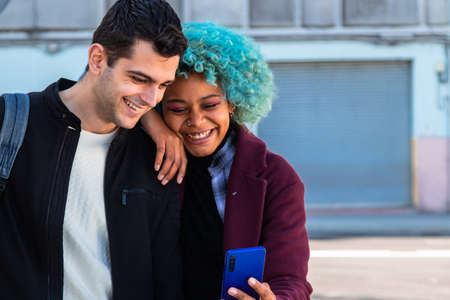 smiling young couple looking at mobile phoneの写真素材