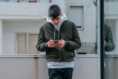 urban casual style teenager typing on mobile phoneの写真素材