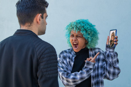 couple fighting on mobile phone or infidelityの写真素材