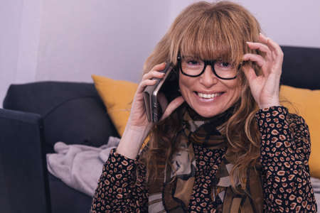 adult woman working at home with mobile phone and computerの写真素材