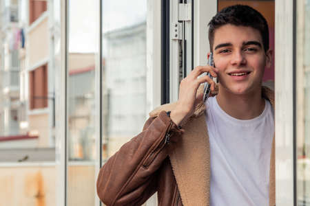 young man talking on the mobile phone at the door