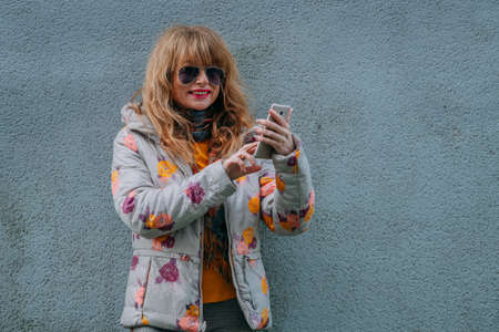 adult woman with mobile phone on the street
