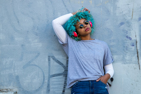 afro american woman with headphones on the wall