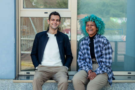 multi-ethnic couple sitting on the street chatting