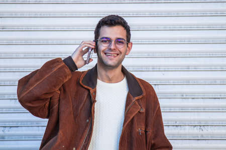 young man talking on mobile phone in the streetの写真素材