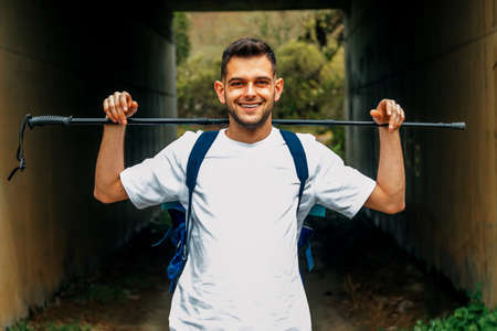 smiling young man with hiking sticksの写真素材