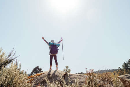 adventurous woman with backpack on top of the mountainの写真素材