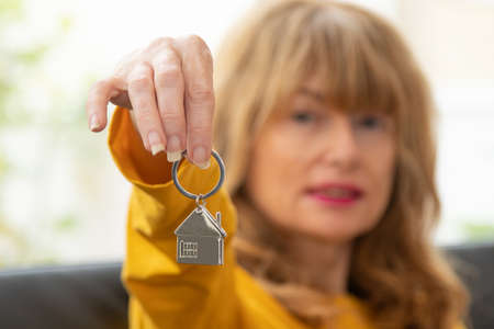 woman with house key in hand, buying houseの写真素材