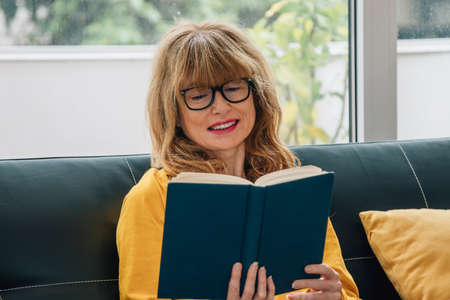 portrait of adult woman reading a bookの写真素材