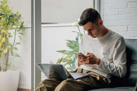 man at home with computer and mobile phoneの写真素材