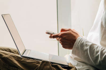 closeup of hands with mobile phone and computer