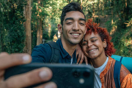 travel couple taking photos with mobile phoneの写真素材