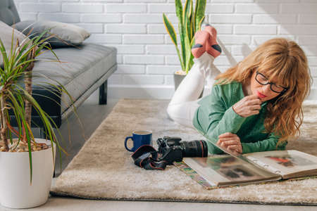 woman at home looking at photo albumの写真素材