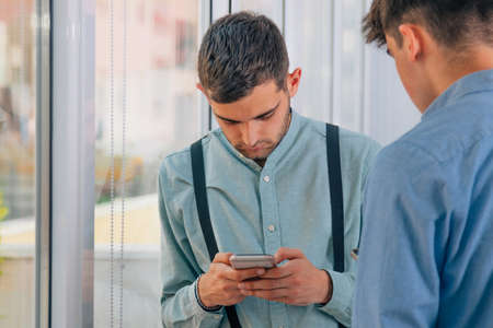 young workers in the office with mobile phonesの写真素材