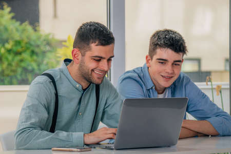 young people with laptops on the desksの写真素材