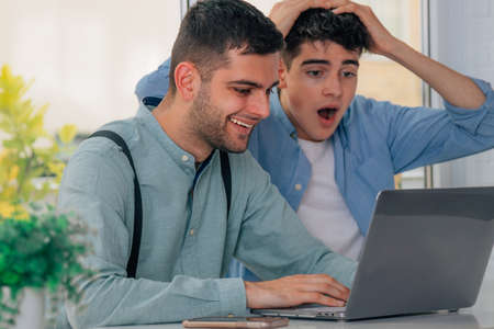 young people looking at the computer in amazementの写真素材
