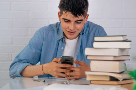 teenage student at the desk with books and mobile phoneの写真素材