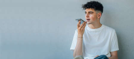 teenager with mobile phone sending voice messageの写真素材