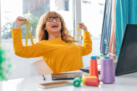 happy woman working in the sewing or design workshop