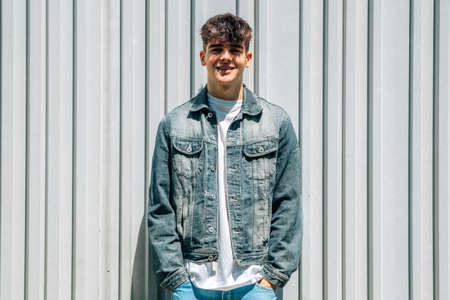 young teenager boy on the wall in denim clothes