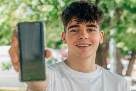 teenage boy showing mobile phone