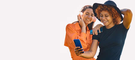 girls couple with mobile phone and headphones on white backgroundの写真素材