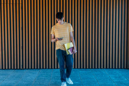 teenage student with books and mobile phoneの写真素材
