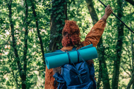 woman with backpack on her back with raised arm