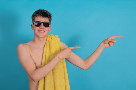 teen boy in swimsuit with towel isolated on backgroundの写真素材