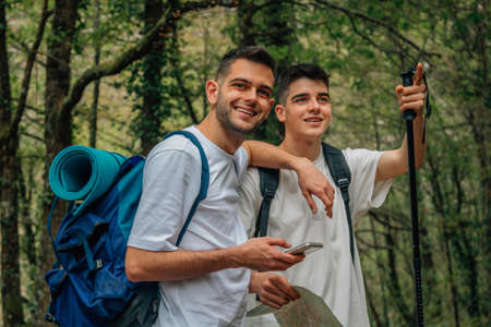 young friends hiking or trekking with a mobile phoneの写真素材