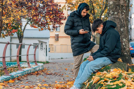 young people with mobile phone on the street