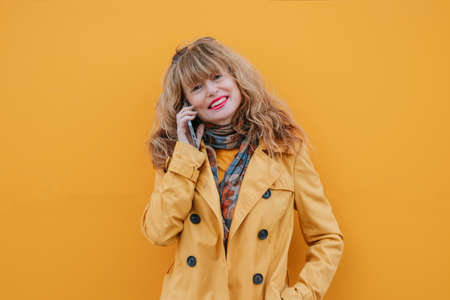 woman on the street with mobile phone and yellow wallの写真素材