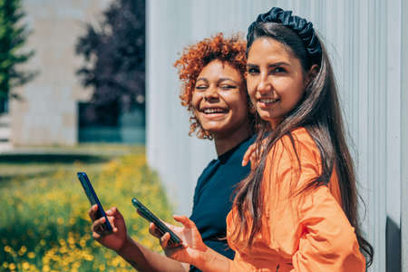 couple of girls on the street with mobile phones