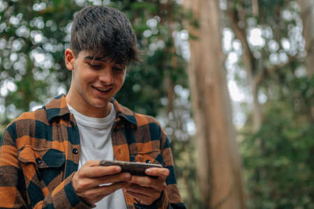 teenage boy with mobile phone outdoorsの写真素材
