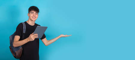 isolated teenage student with tablet and backpack in backgroundの写真素材