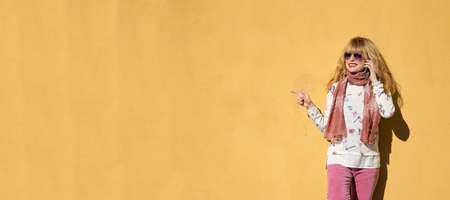 woman with mobile phone on the street wall with space