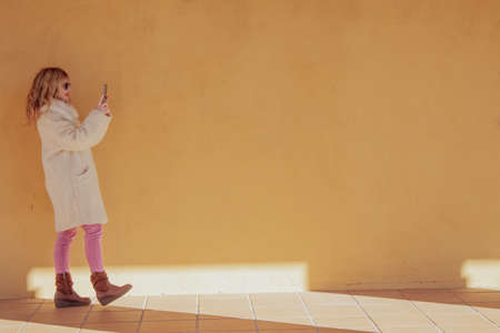 woman walking with mobile phone on the streetの写真素材