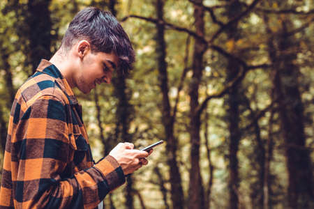 young teenager with mobile phone texting or typingの写真素材