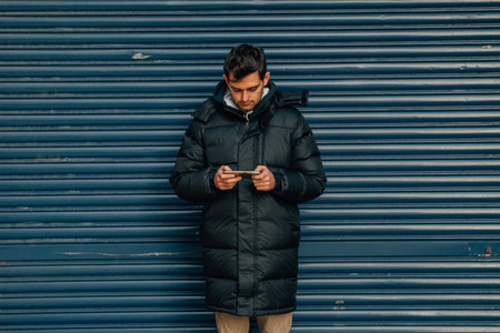 man with mobile phone on the street in coat