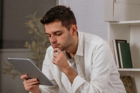young man at home with digital tablet or computer