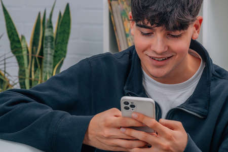 teenage boy at home with mobile phoneの写真素材