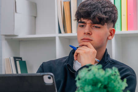 pensive teenage student with laptop studyingの写真素材