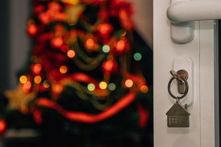keys in open door lock with christmas tree inside houseの写真素材
