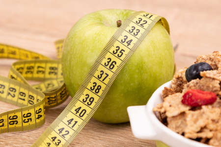 cereal bowl top view with measuring tape, health and diet concept