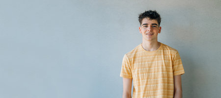 casual teenager portrait isolated on wall backgroundの写真素材