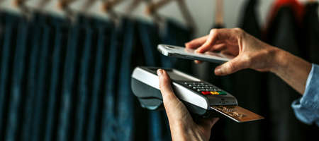 hand paying with mobile phone in storeの写真素材